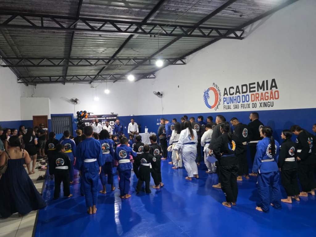 Famílias e comunidade reunidas acompanhando o evento na academia